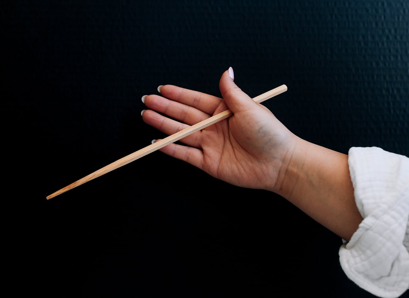 holding chopsticks between thumb and resting on pinkie