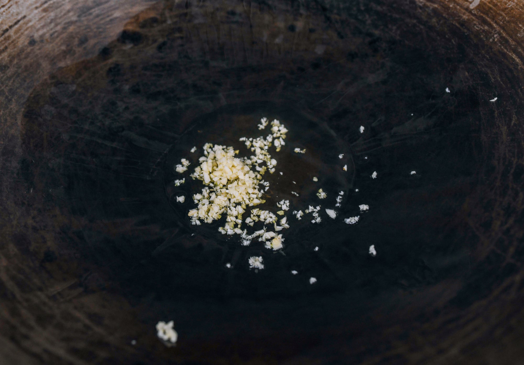 minced garlic in oil in wok