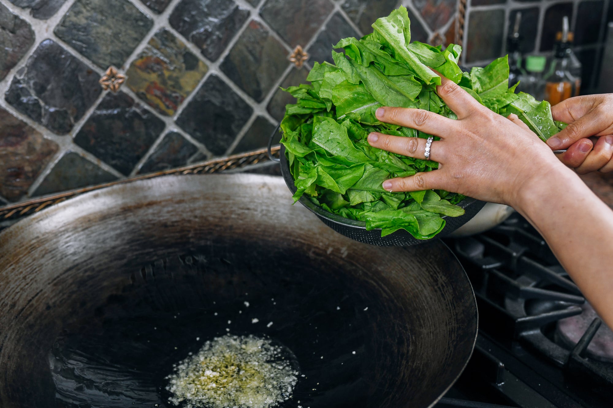 adding A choy to garlic and oil in wok
