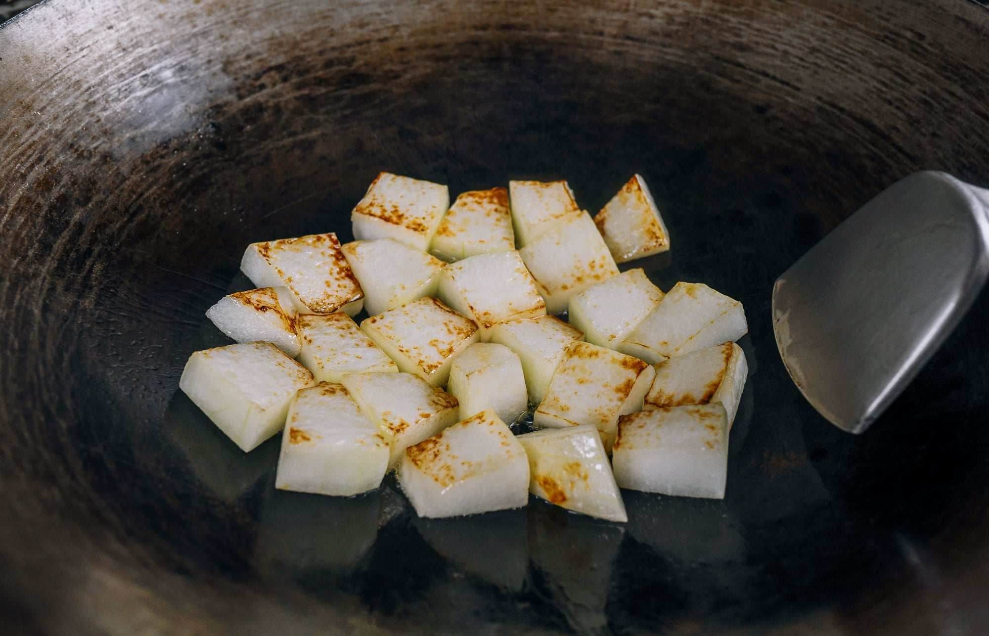 seared chunks of winter melon in wok