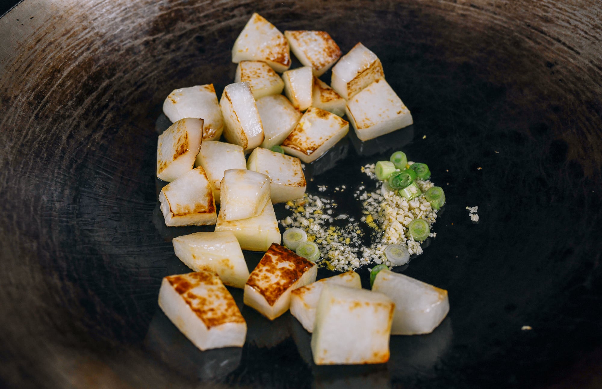 ginger, garlic, and scallion whites in wok with winter melon