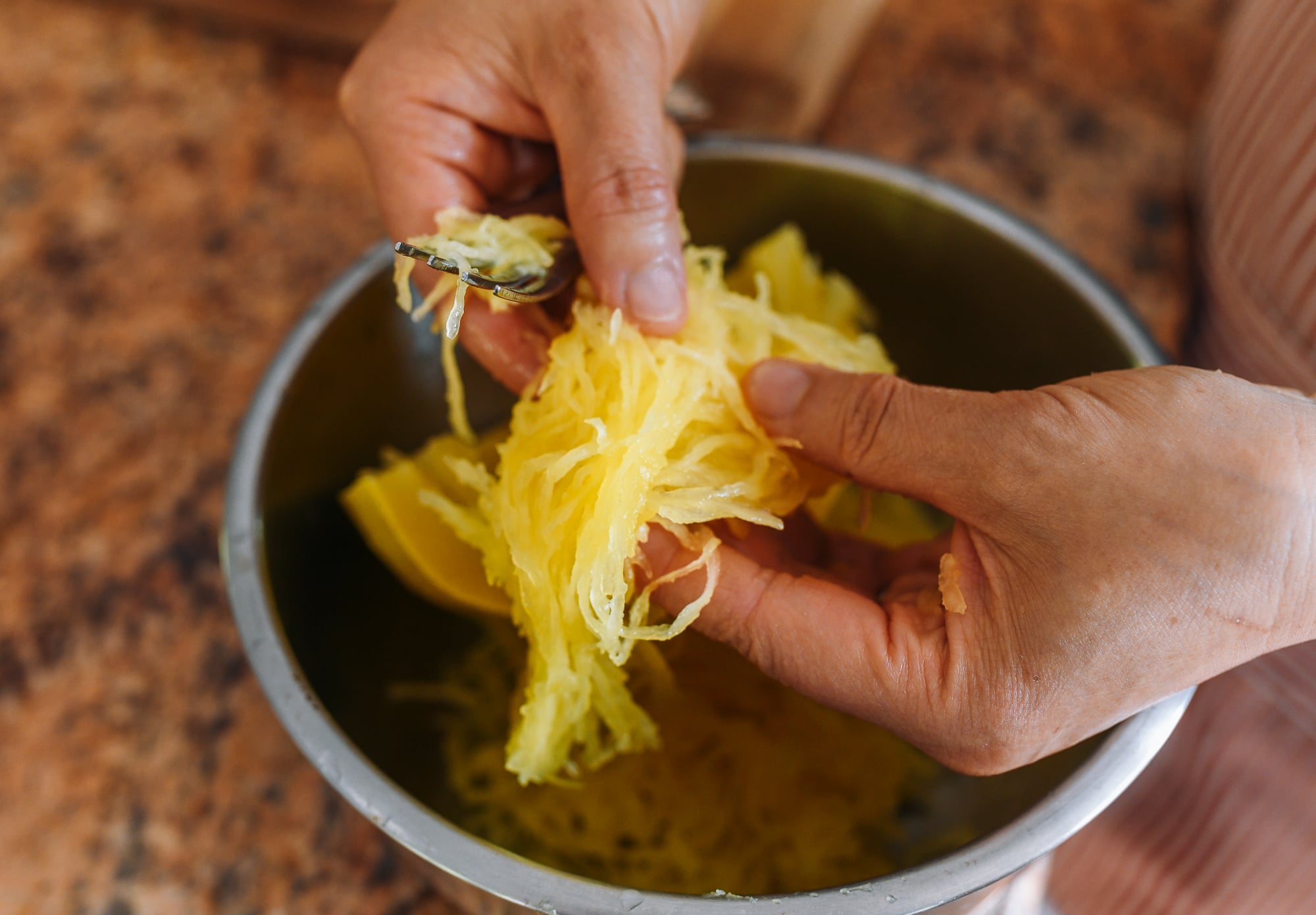 breaking apart spaghetti squash strands
