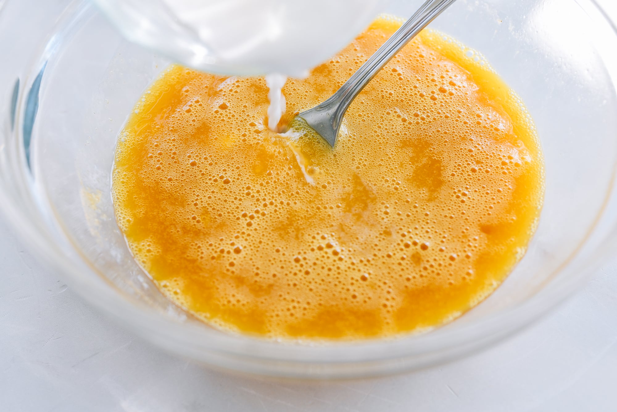 pouring cornstarch slurry into beaten eggs
