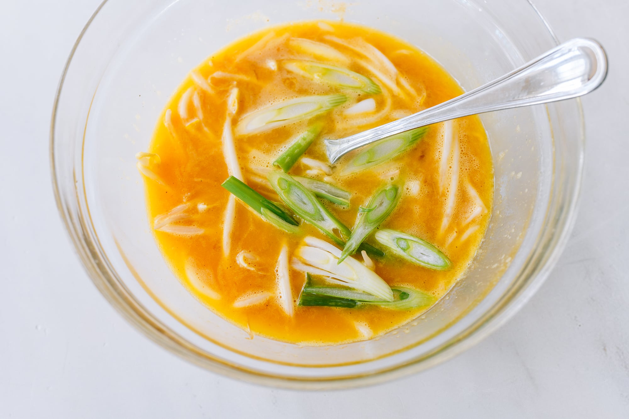 scallion whites added to beaten eggs with bean sprouts