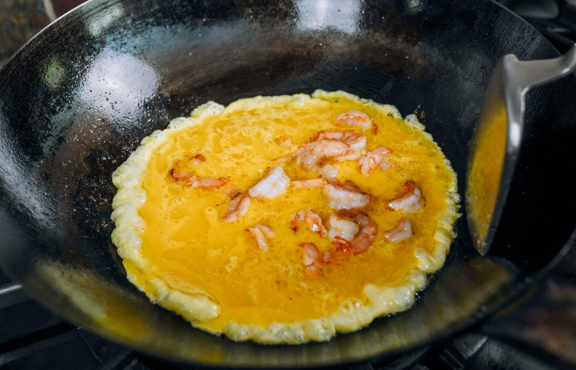 shrimp added to egg in wok