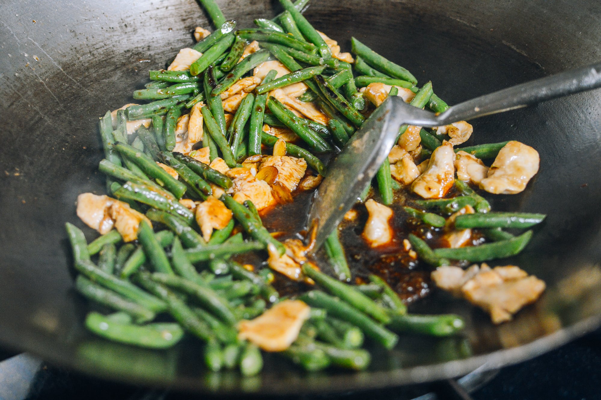 chicken, string beans adn sauce in wok