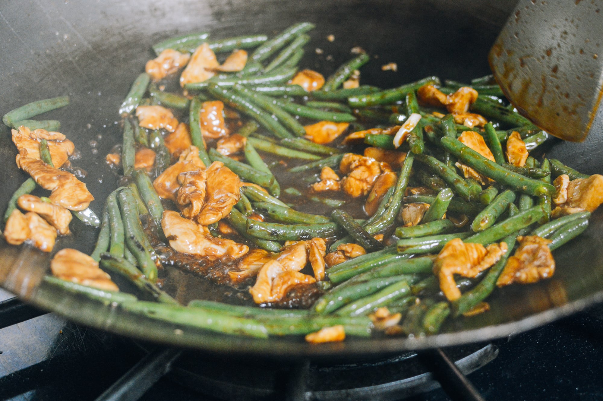 chicken string beans and sauce in wok
