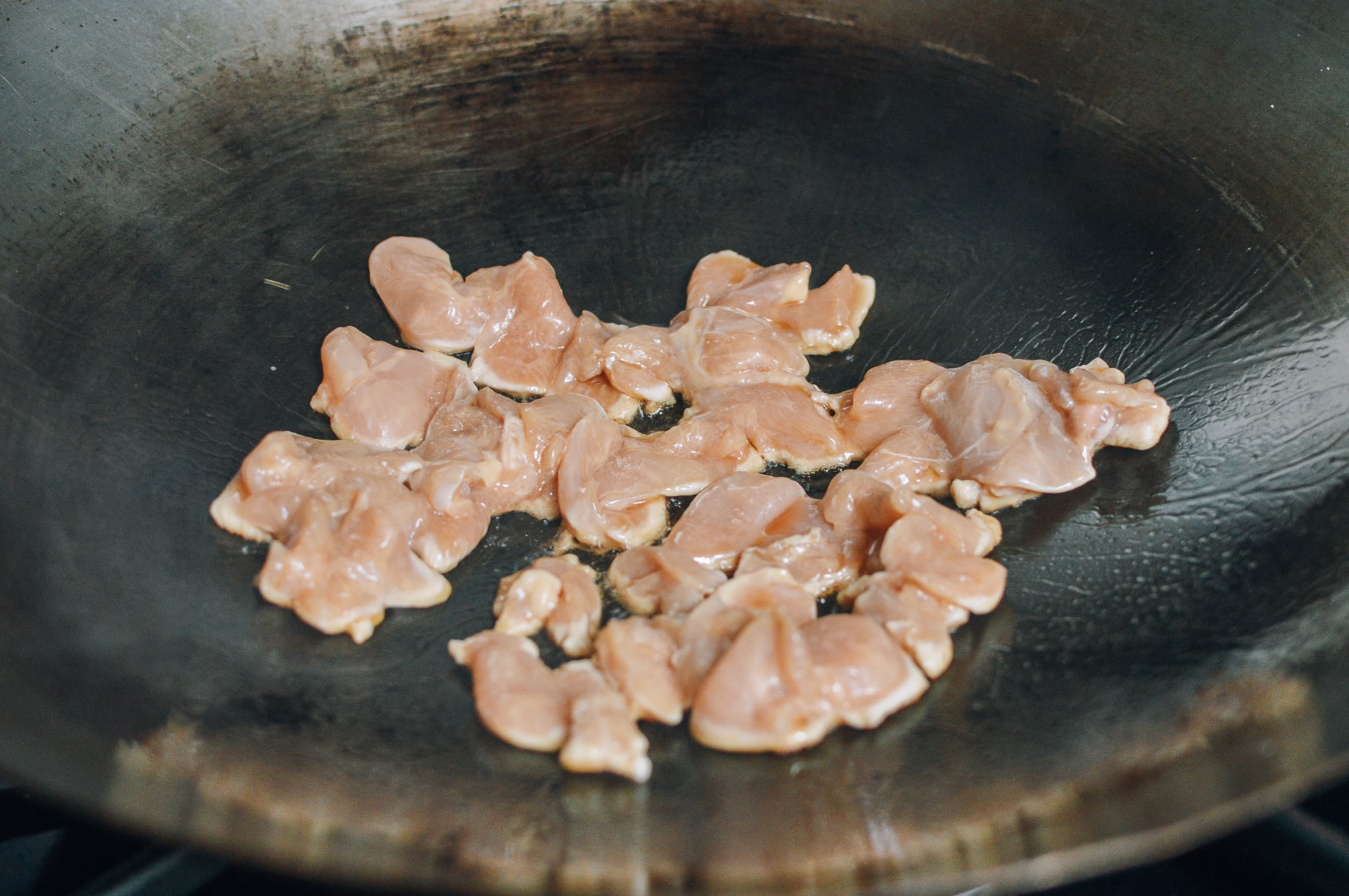 searing chicken breast pieces in wok