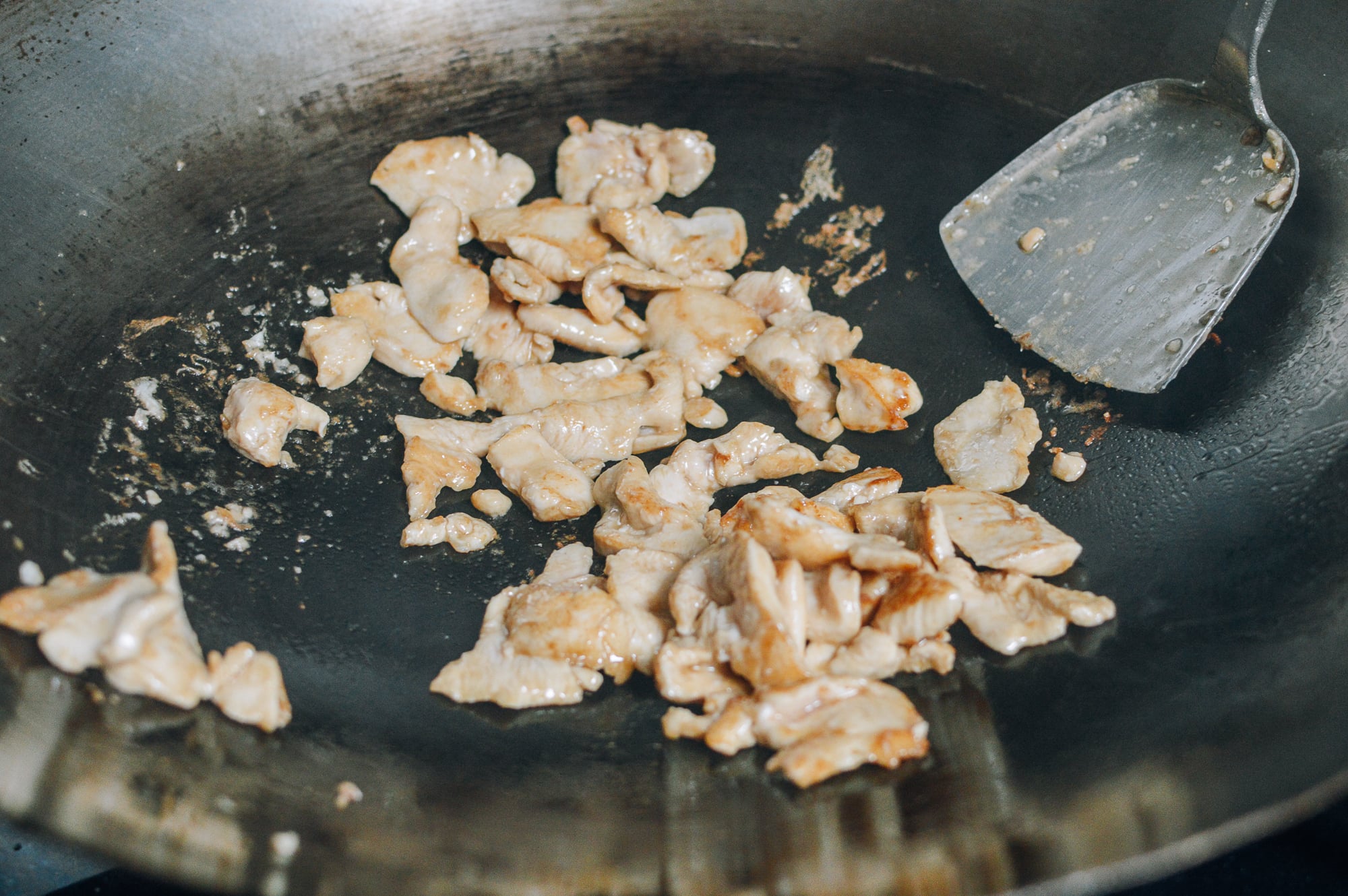 seared chicken breast pieces in wok