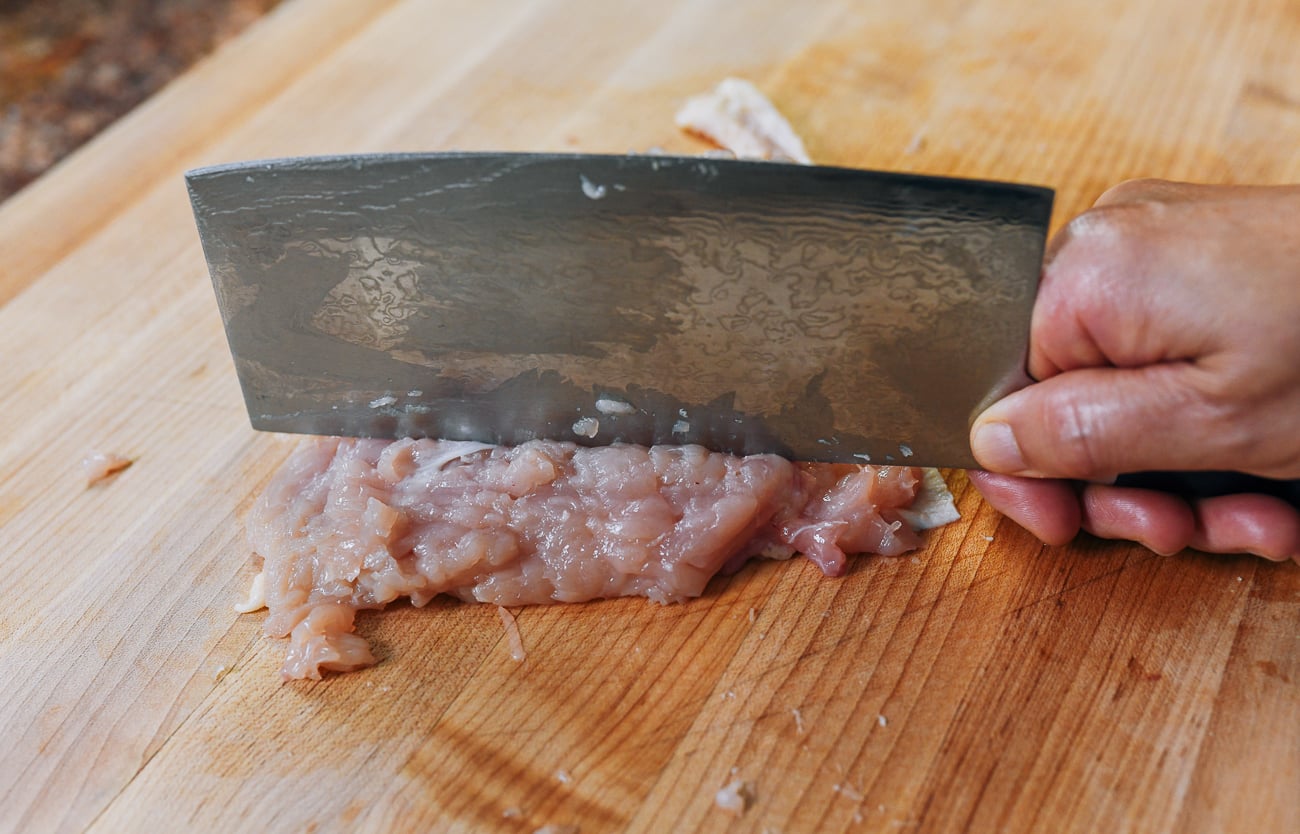 pounding chicken breast with the back of a chinese cleaver