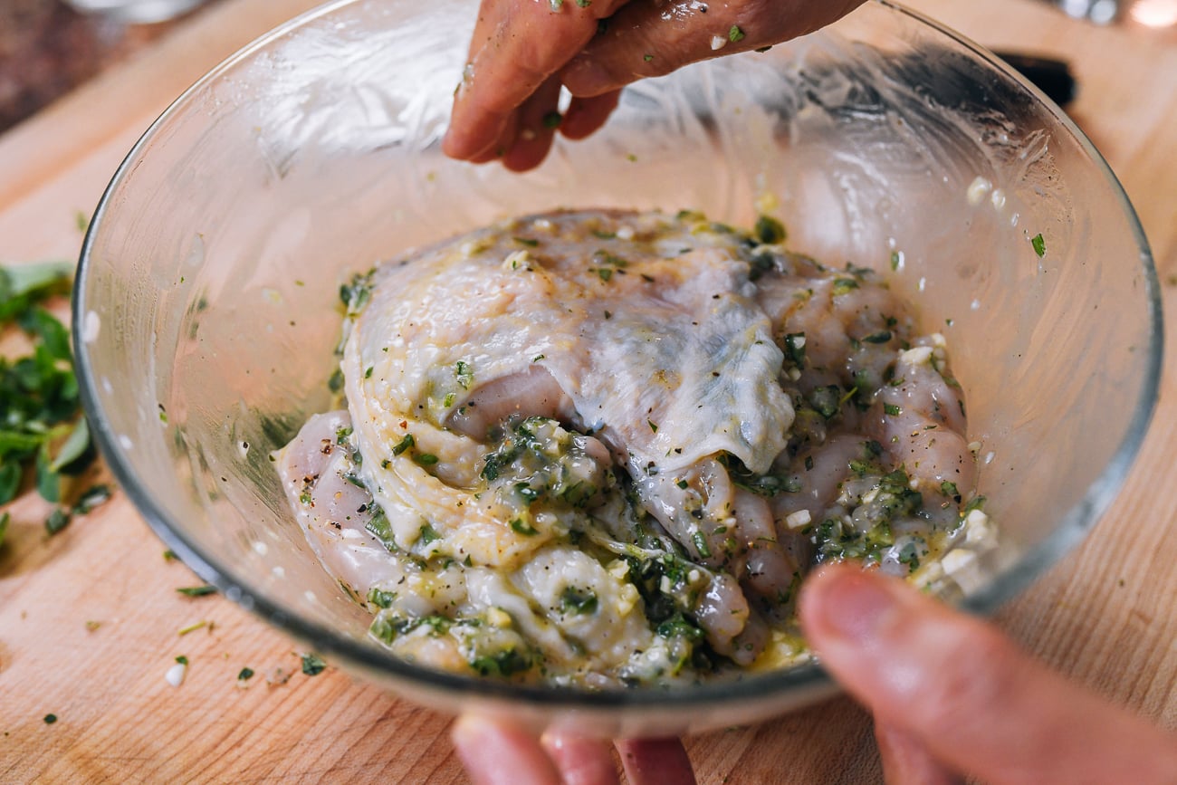 mixing chicken breast with marinade ingredients