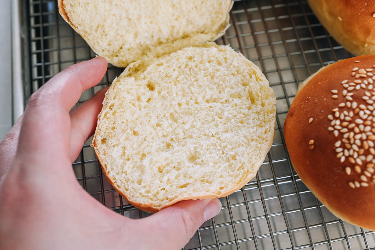 squeezing sides of freshly baked homemade hamburger roll