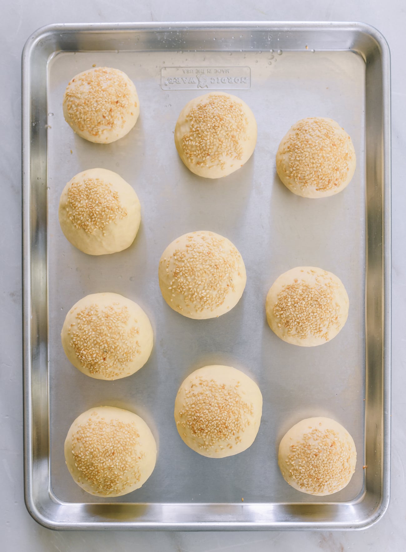 hamburger buns on baking sheet before proofing