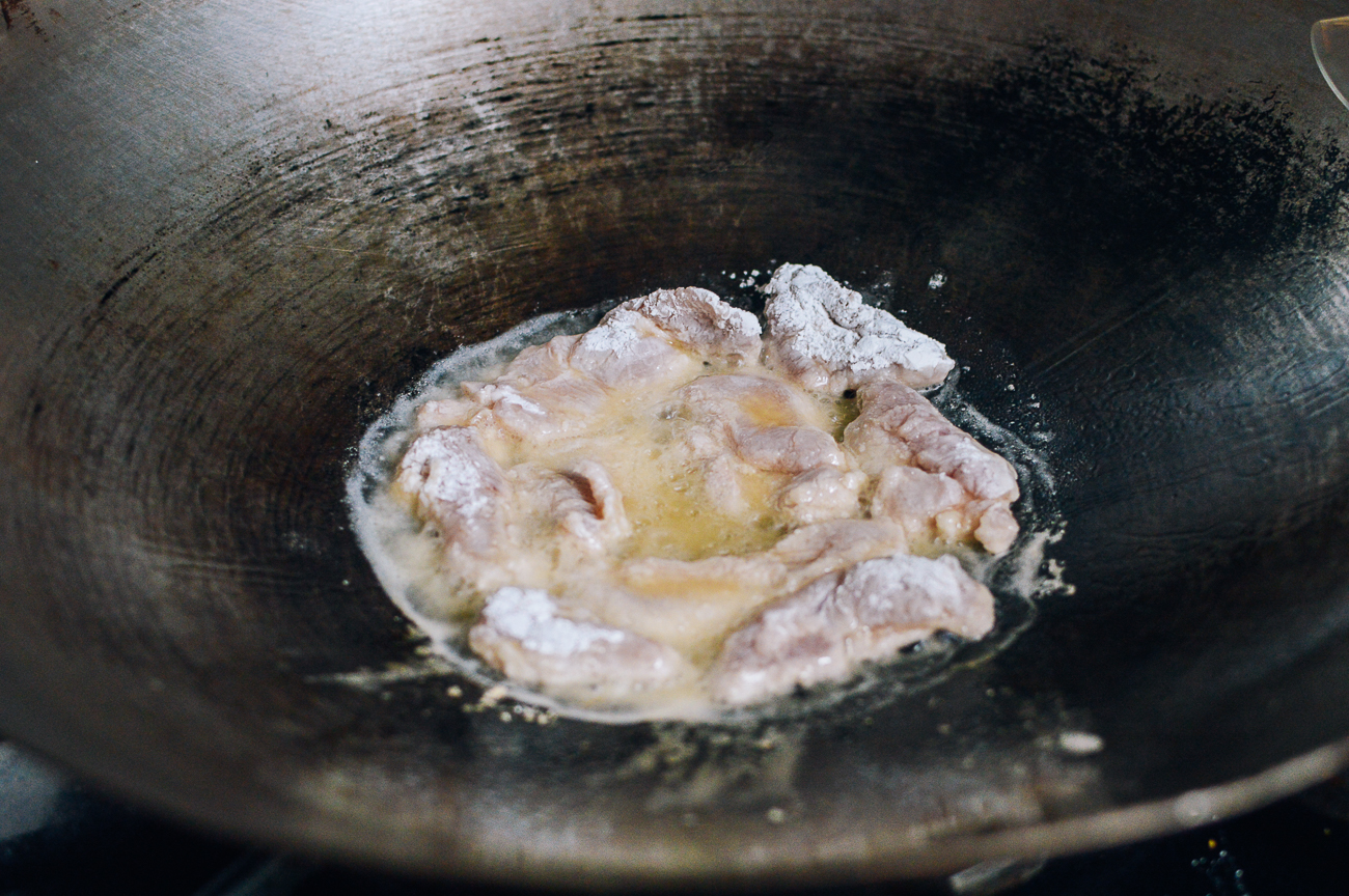 shallow frying cornstarch dredged chicken in wok