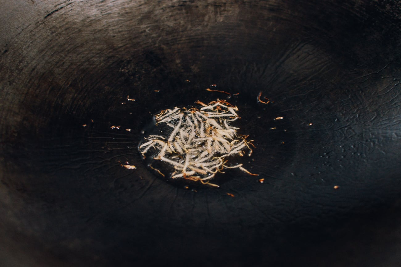 julinned ginger in oil in wok