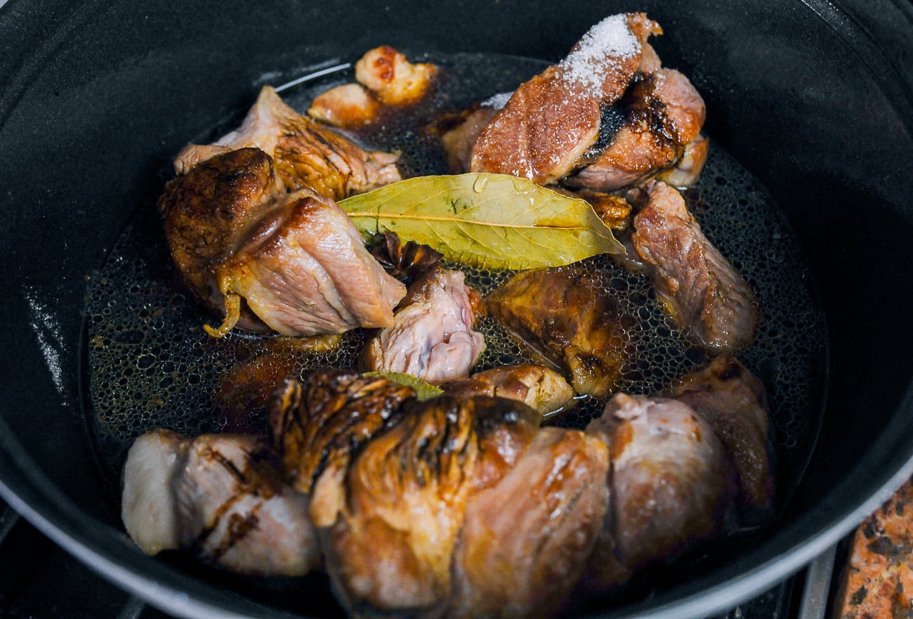 pork shoulder pieces in pot with rice wine, soy sauce, water, bay leaves, star anise