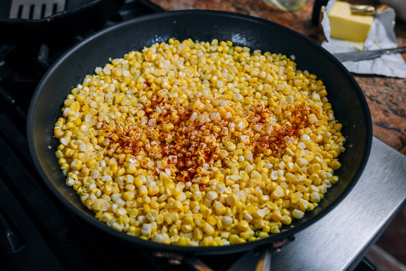 seasoning corn with smoked paprika, salt and pepper