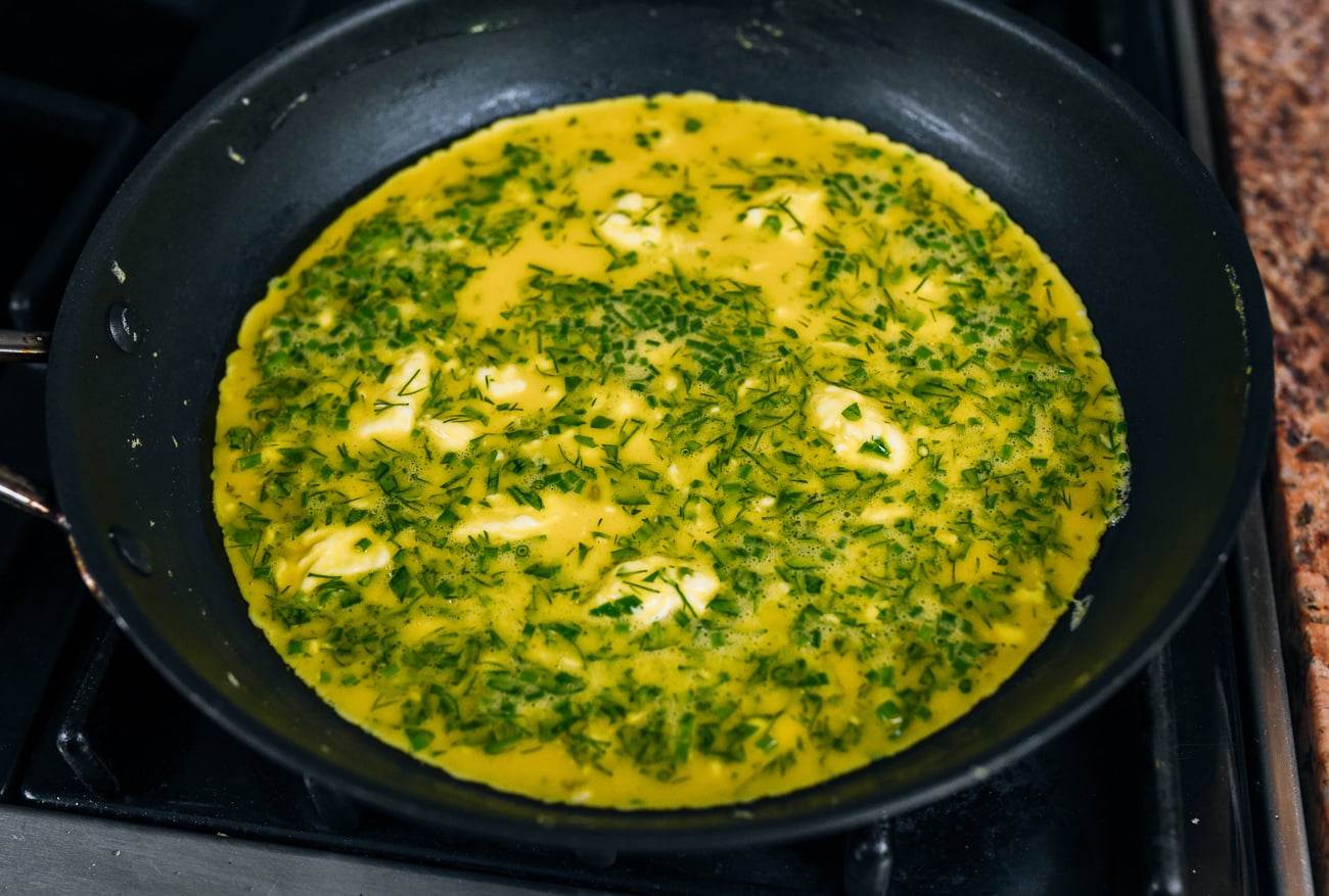 cooking scrambled eggs with herbs