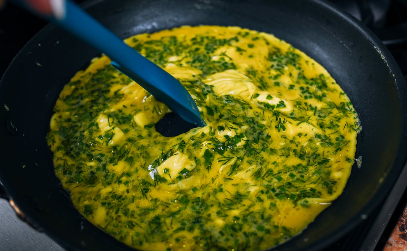 scrambling eggs with finely chopped herbs