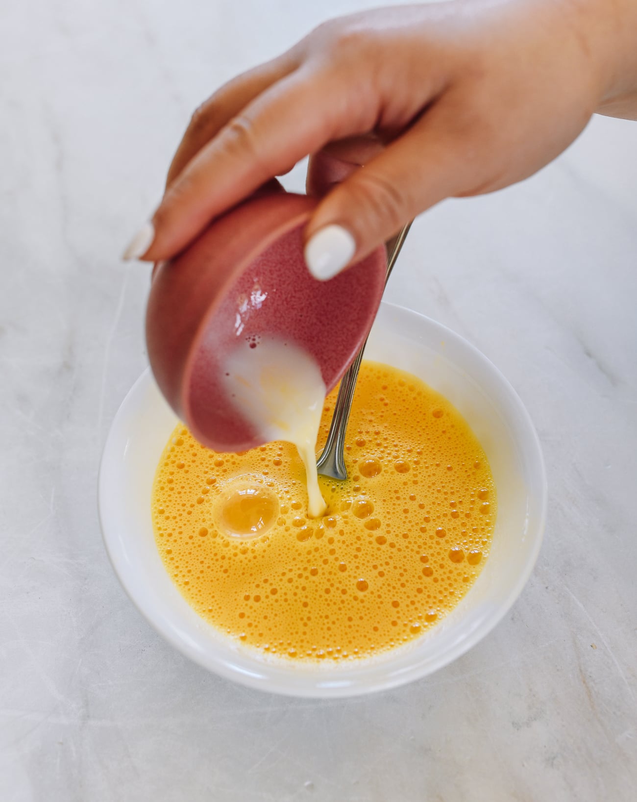 pouring cornstarch slurry into eggs
