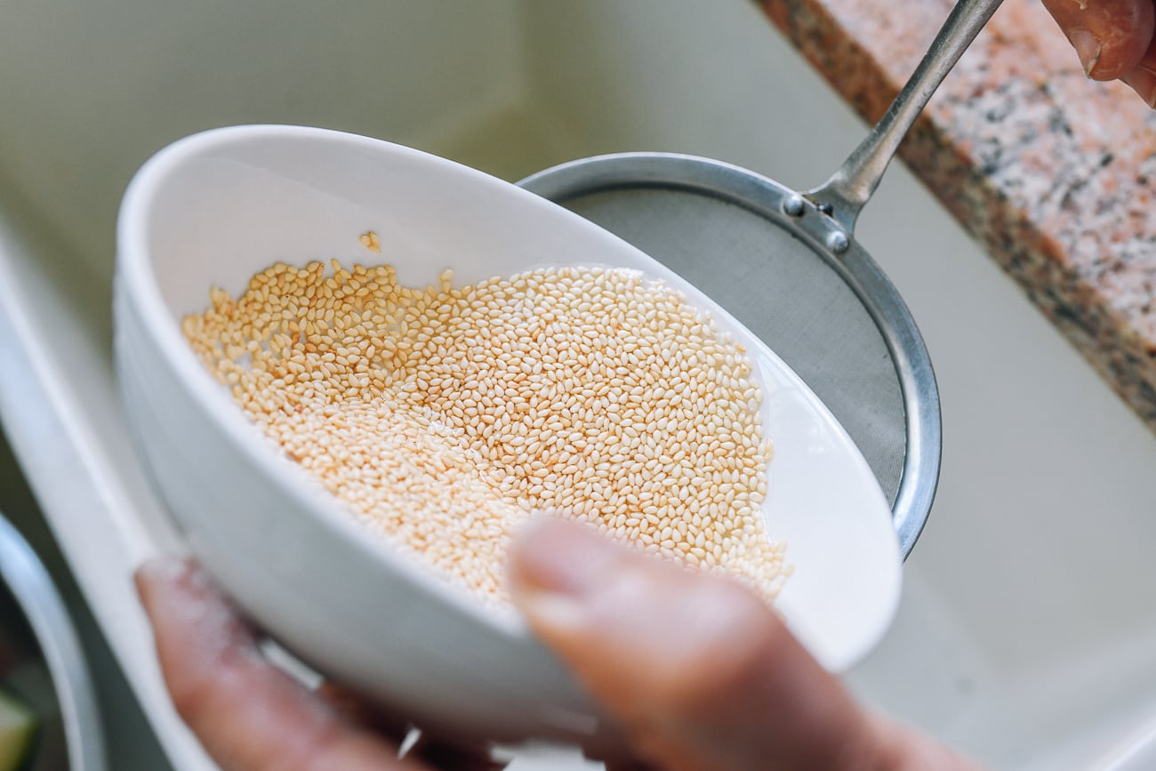 straining sesame seeds in water