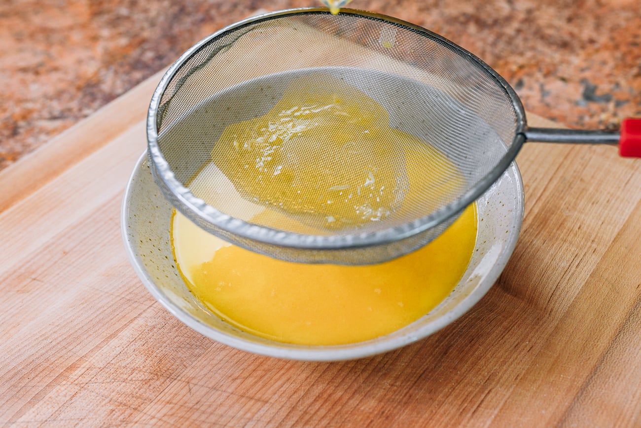 egg white caught in fine mesh strainer