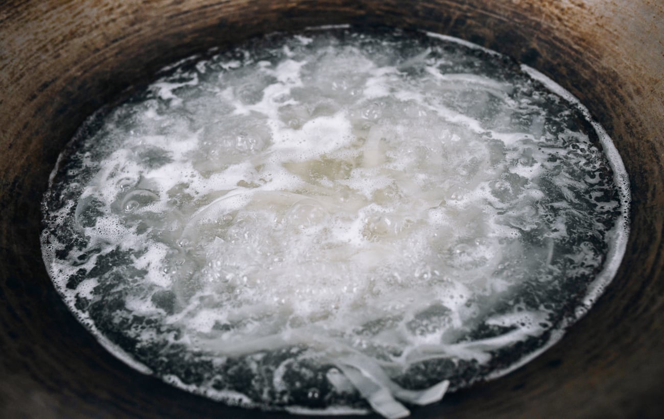Wide Rice Noodles boiling in wok