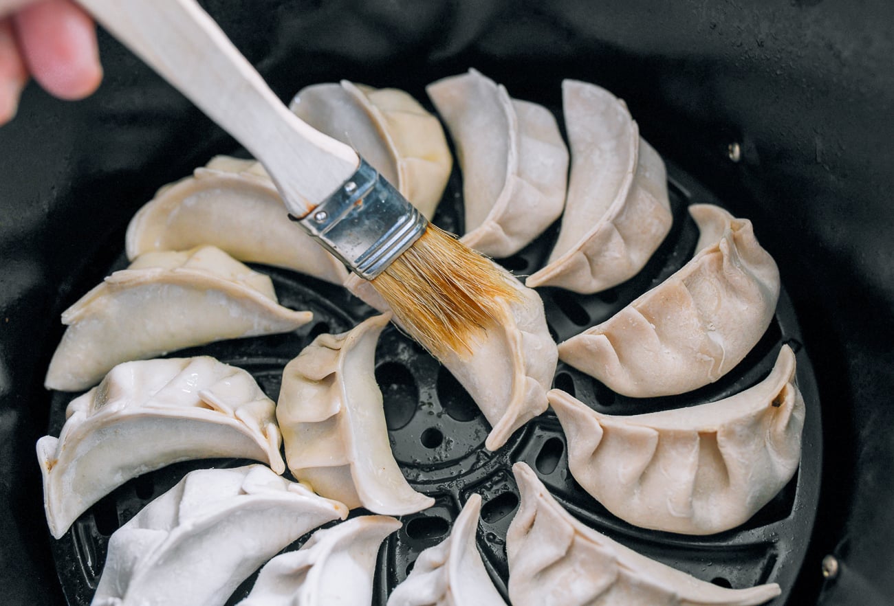 using pastry brush to brush oil on dumplings in air fryer