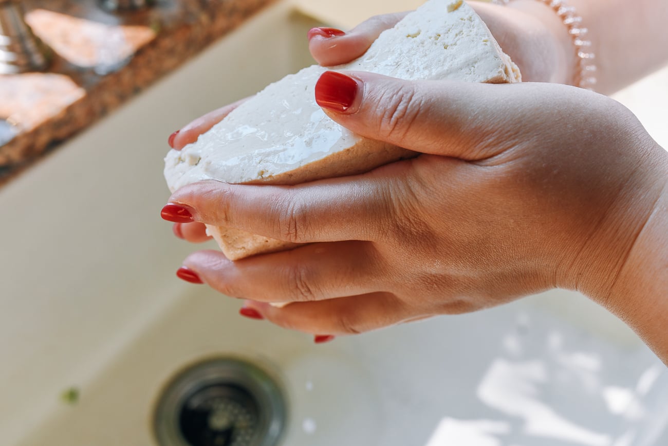 squeezing water out of block of firm tofu