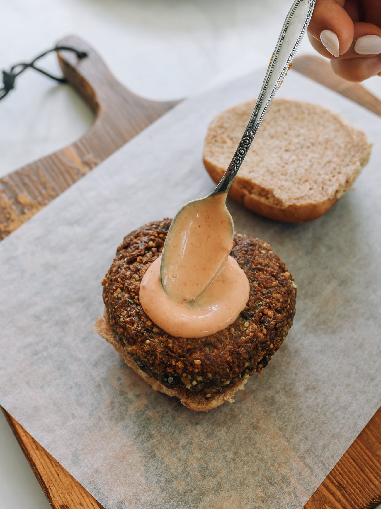 spreading yum yum sauce on tofu burger