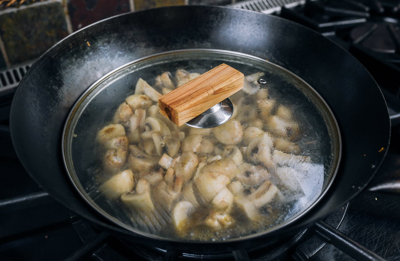 cooking mushrooms in covered wok