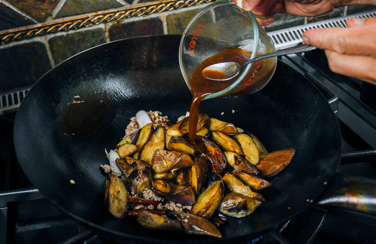 pouring sauce mixture into fish fragrant eggplant