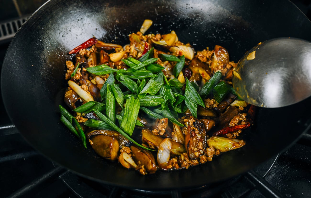 adding green portion of scallions to fish fragrant eggplant