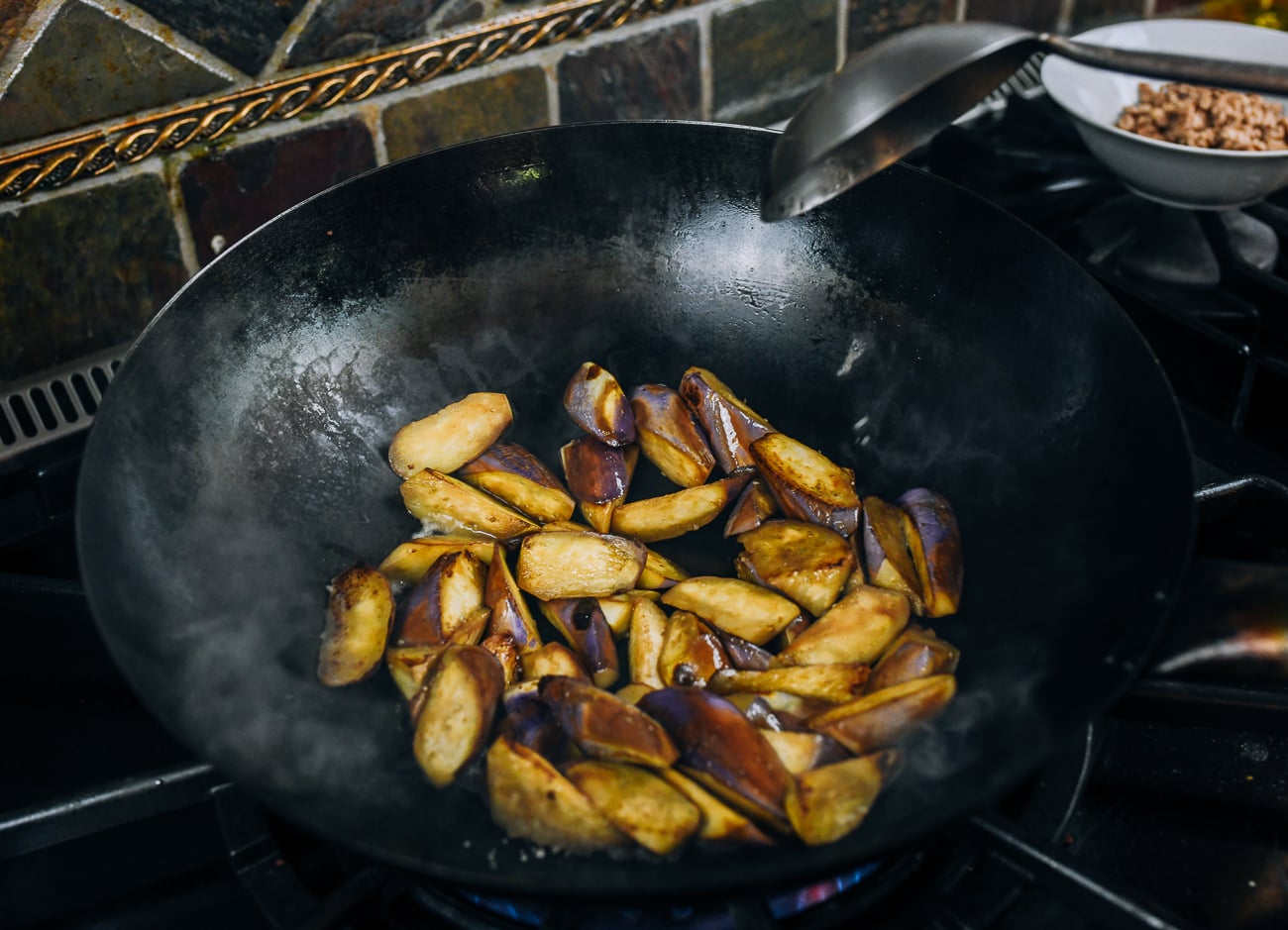 searing eggplant pieces in wok