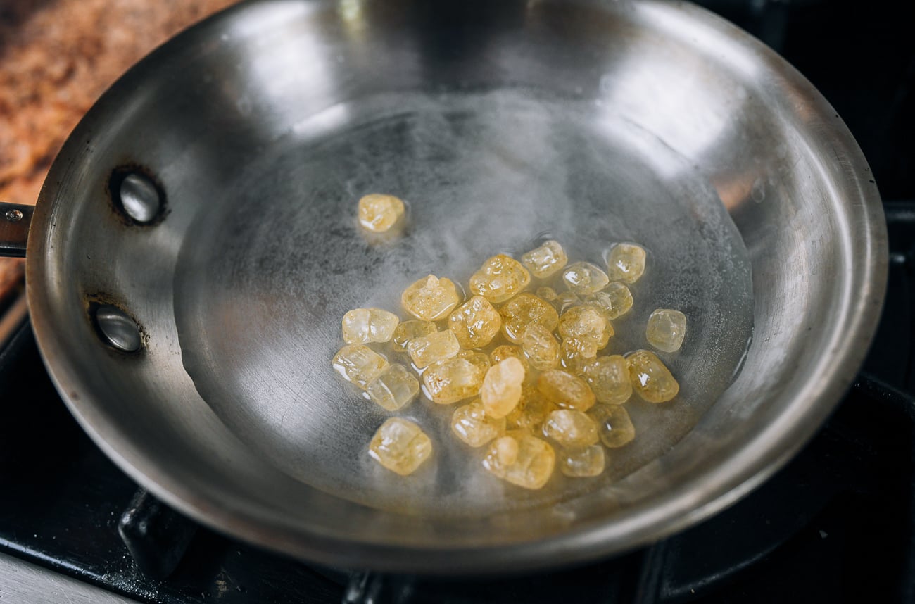 dissolving rock sugar in water in pan