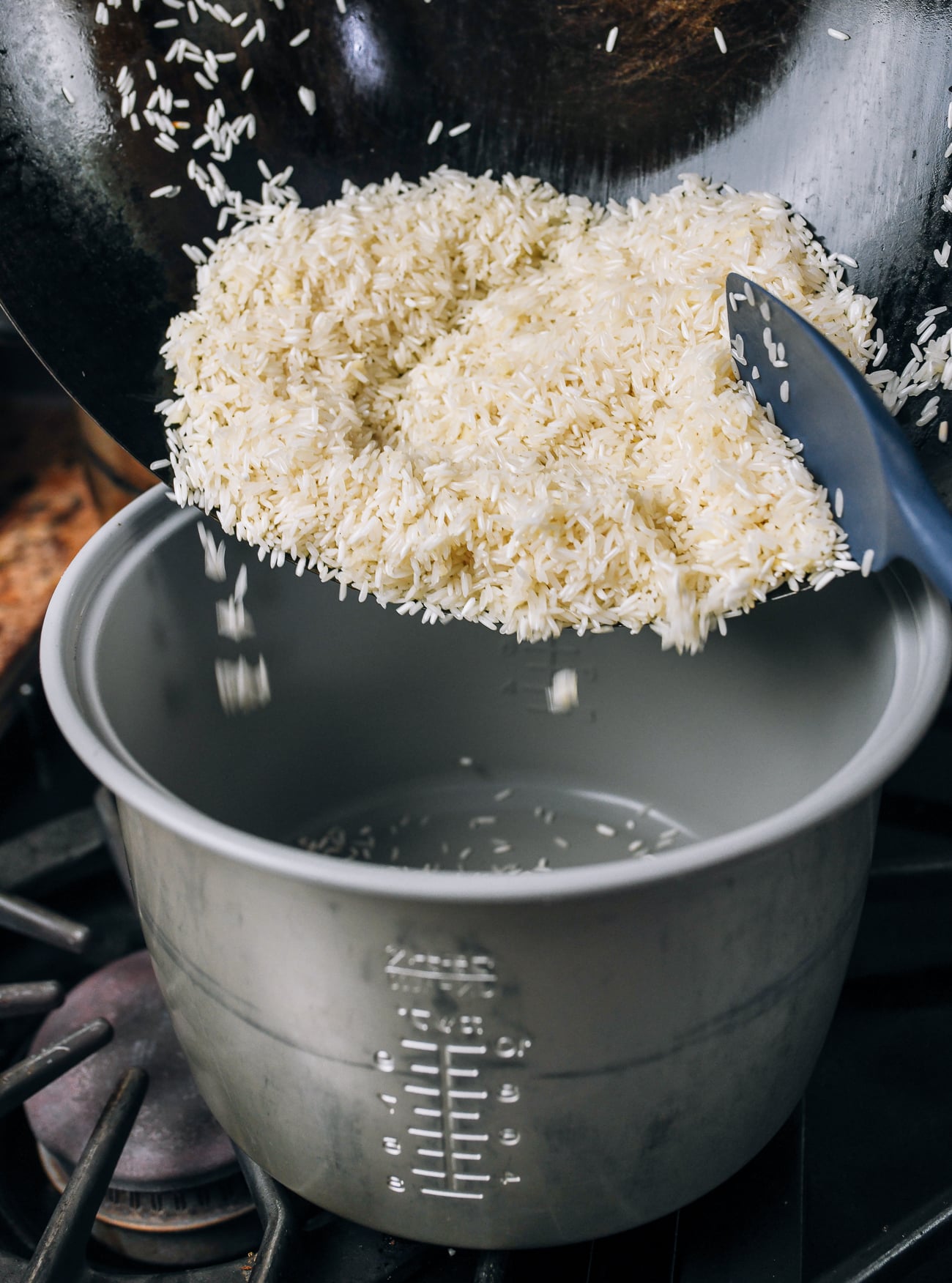 adding rice to rice cooker pot