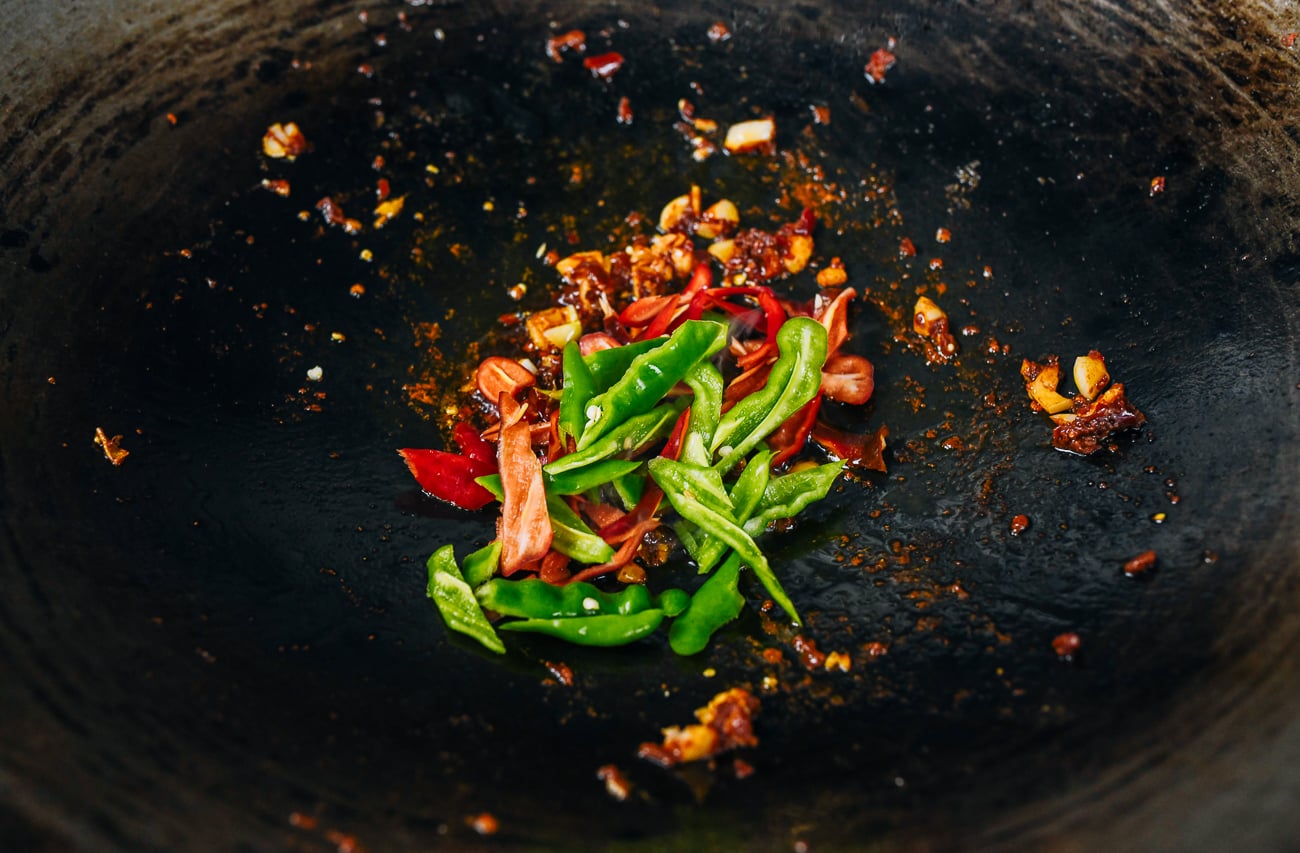 peppers added to spicy bean sauce and garlic