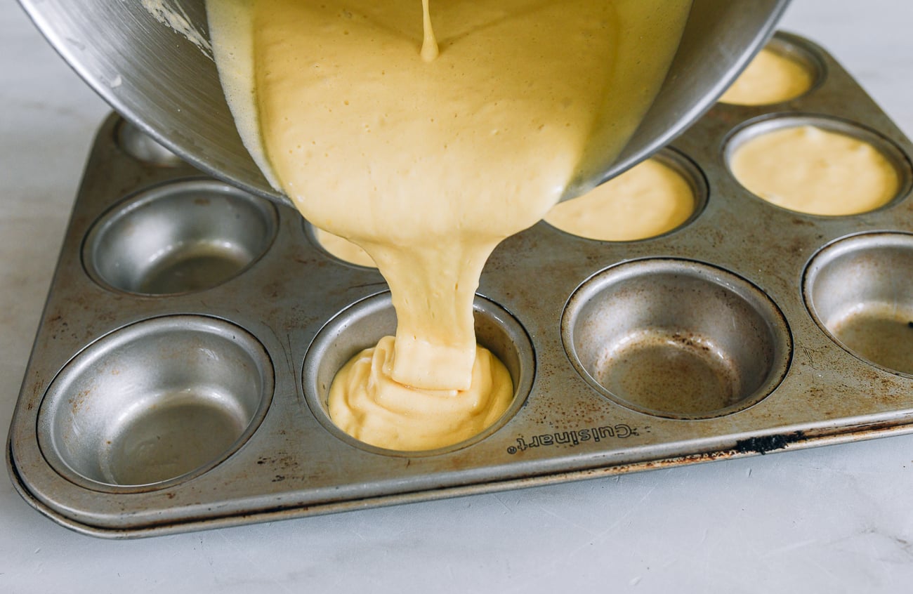 batter pouring in ribbon stage into muffin tin