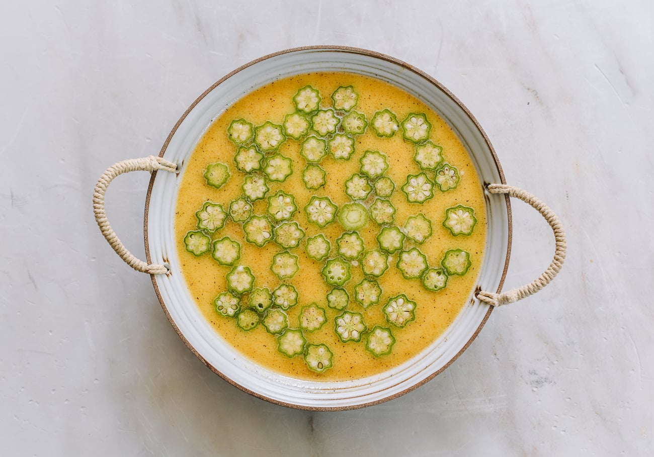 okra slices floating on top of egg mixture in dish