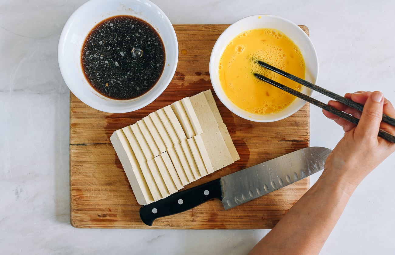 sauce mixture in bowl, beaten egg in bowl, and sliced tofu