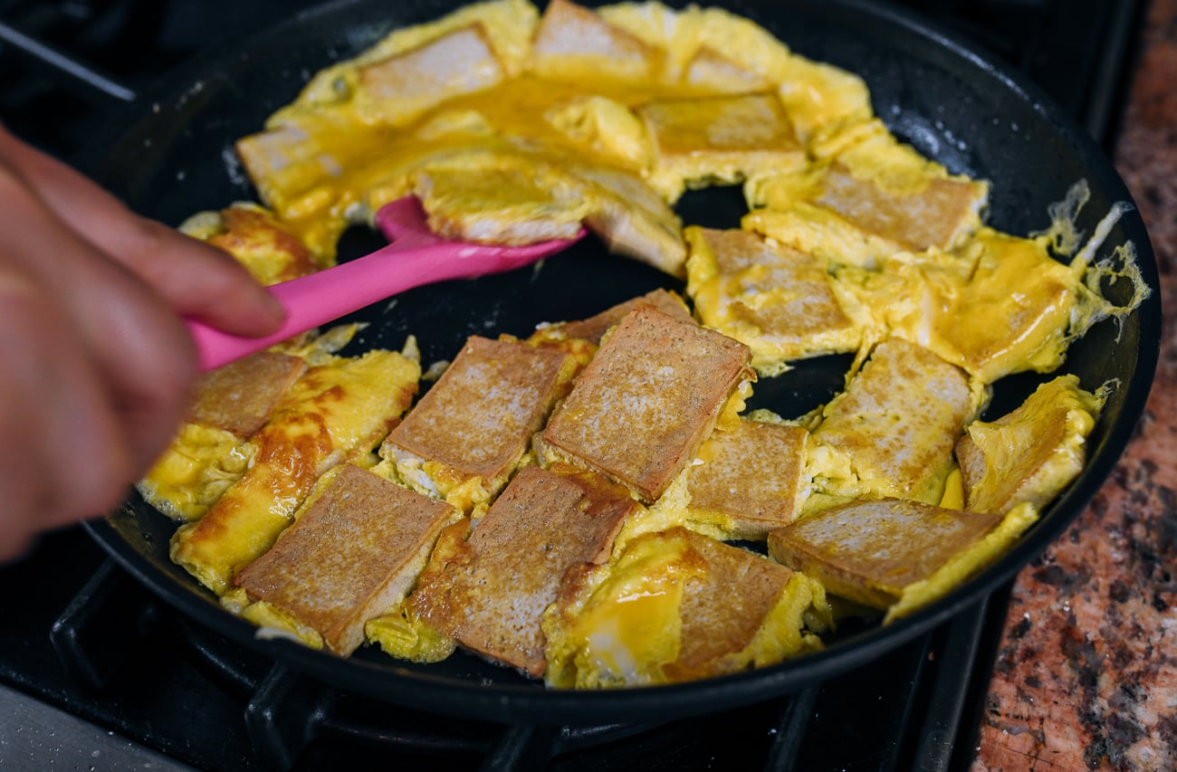 flipping the egg and tofu over 
