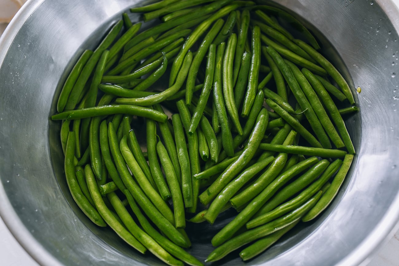 washing green beans in large metal bowl of water