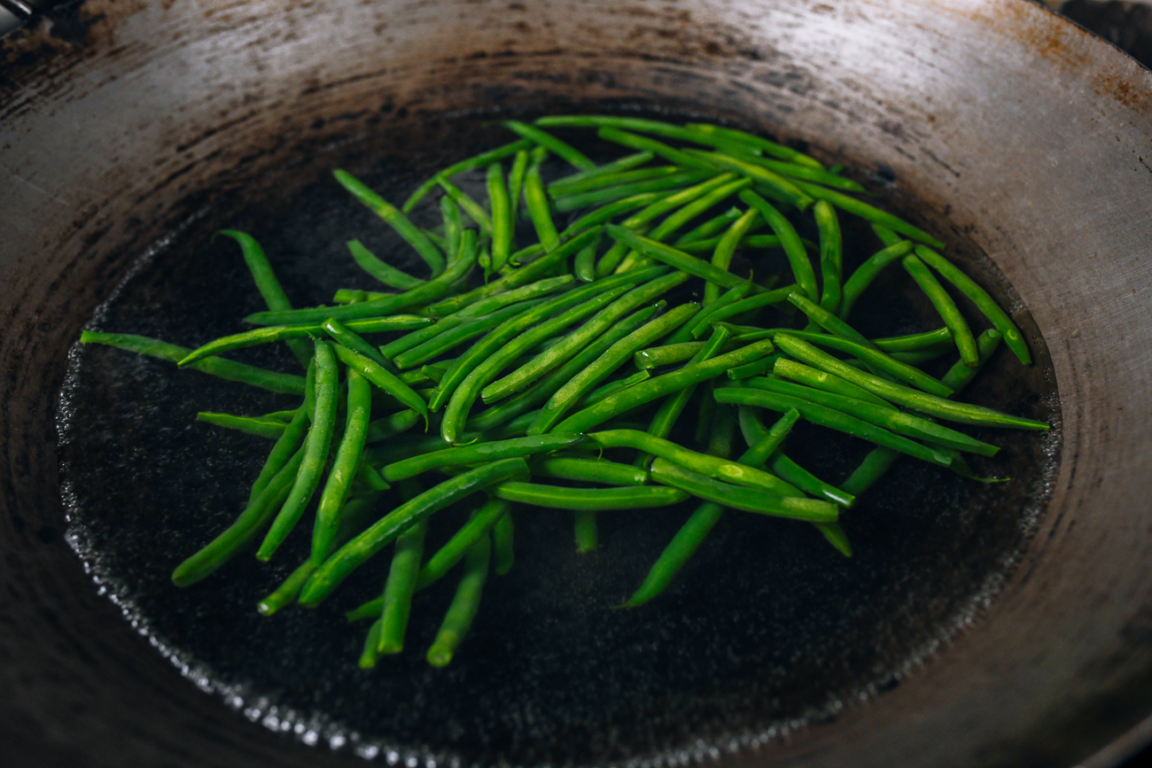 blanching green beans in a wok