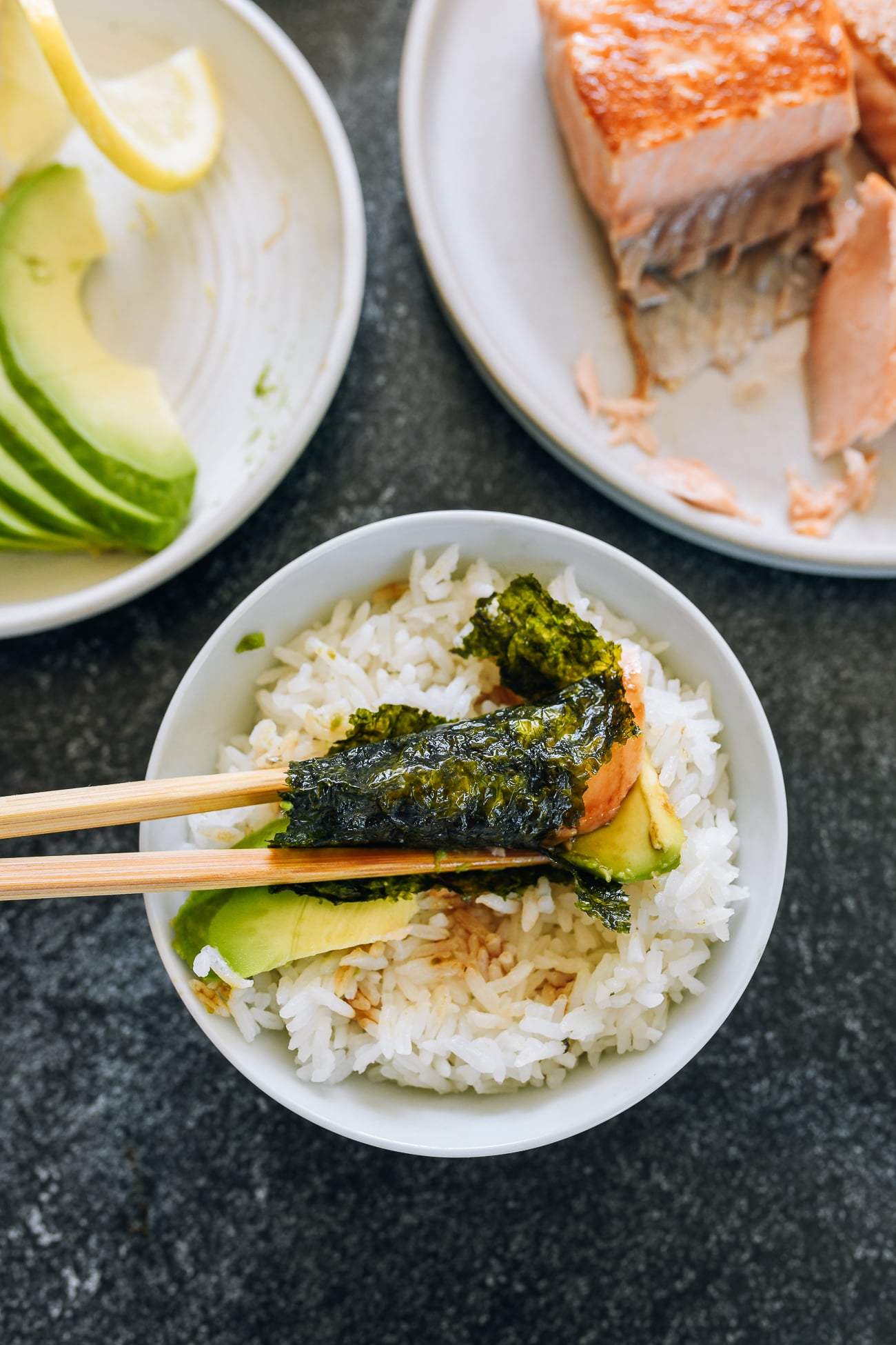wrapping roasted seaweed sheet around avocado, salmon, and rice