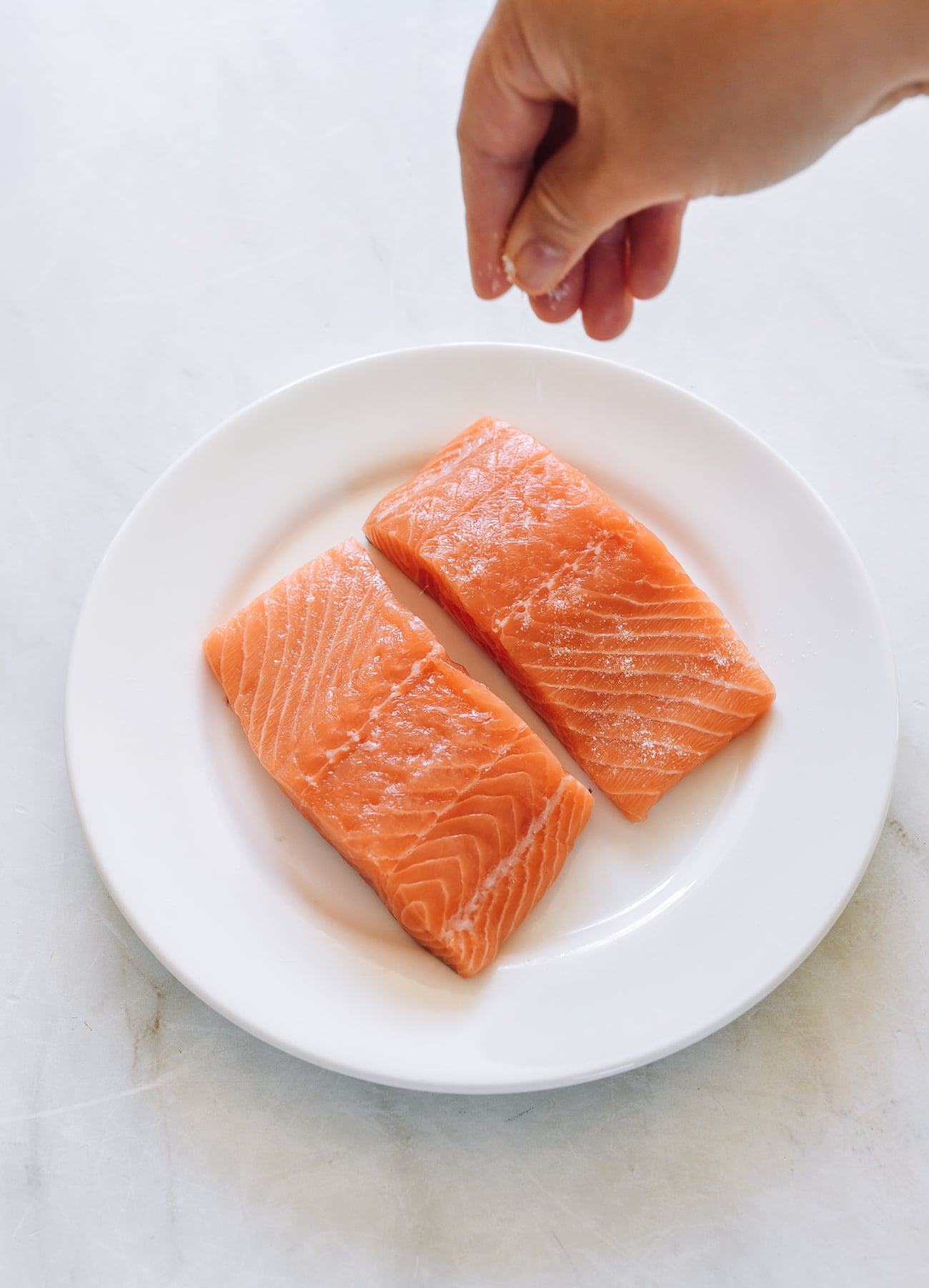 sprinkling salmon filets with salt