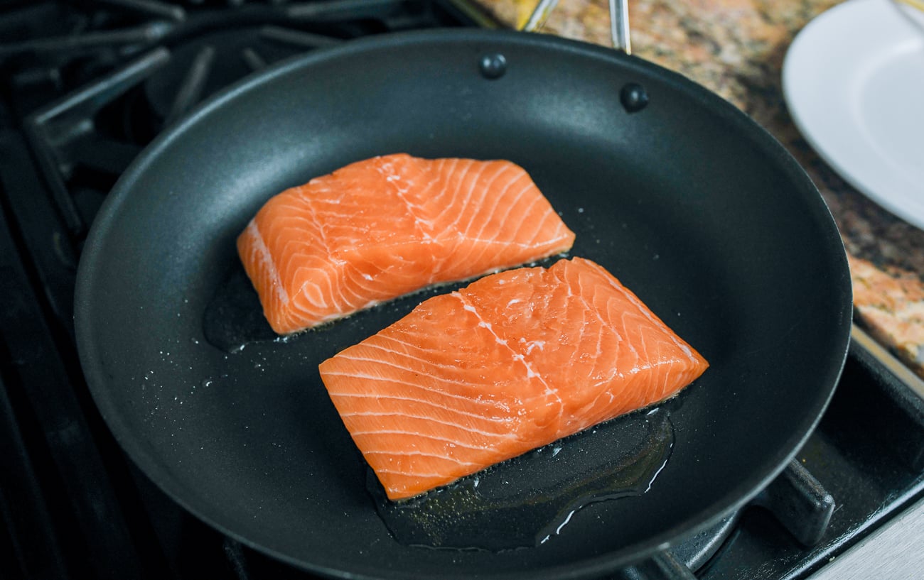 salmon filets in nonstick pan skin-side down