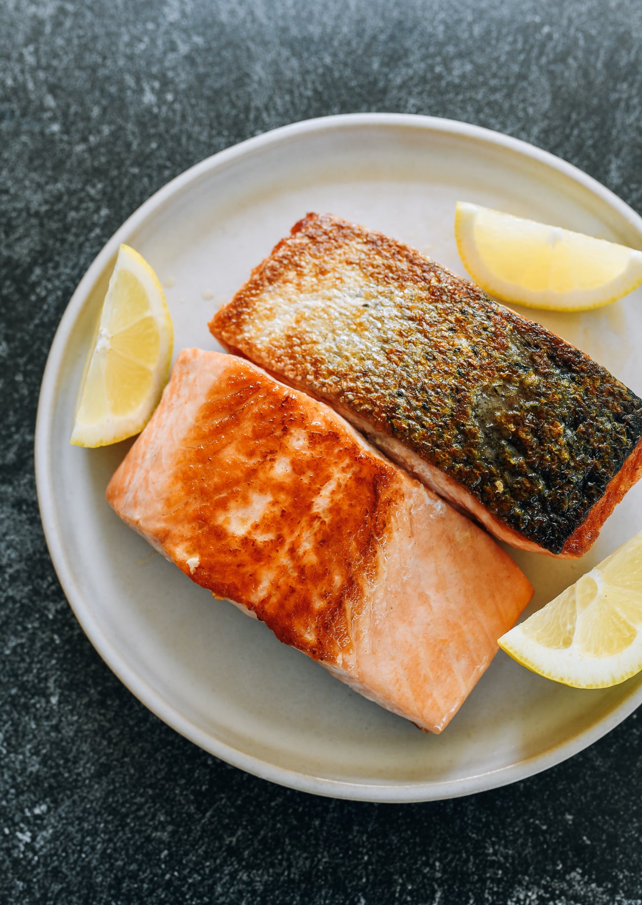pan fried salmon with lemon wedges