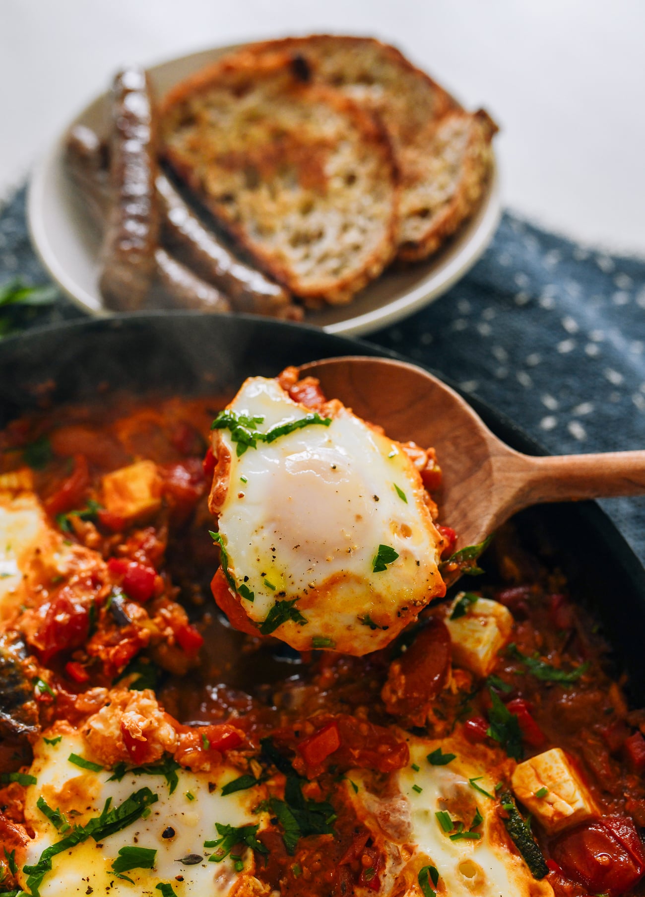 Pulling a cooked egg out of shakshuka