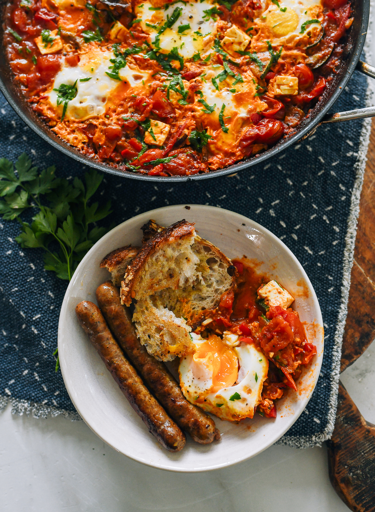 Shakshuka served with bread and merguez sausage