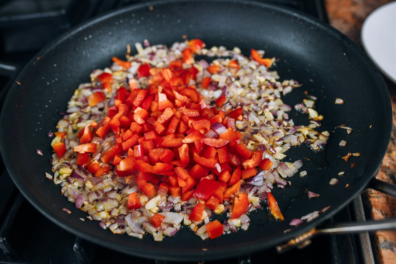 diced red bell pepper added to onions and garlic